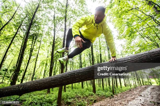 adult man running in forest in bad weather - assault courses stock pictures, royalty-free photos & images