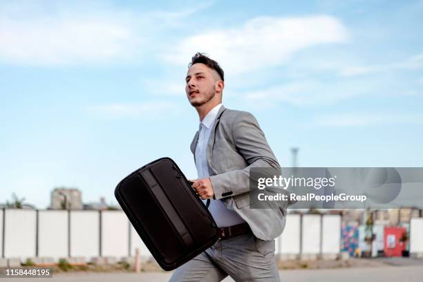 young businessman running in a city street - running man profile stock pictures, royalty-free photos & images