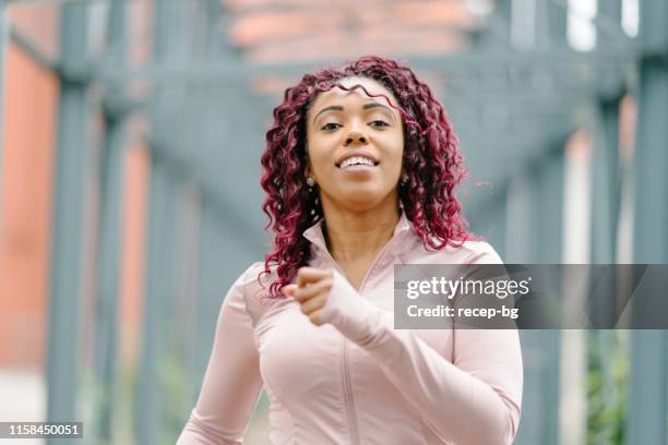 portrait of female athlete while running - center athlete stock pictures, royalty-free photos & images