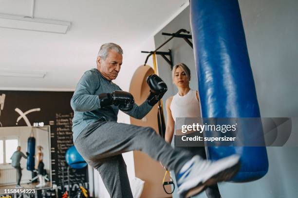 senior man exercising with his personal trainer - senior kicking stock pictures, royalty-free photos & images