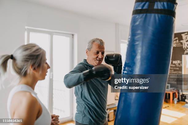 senior man oefenen met zijn persoonlijke trainer - old man young woman stockfoto's en -beelden