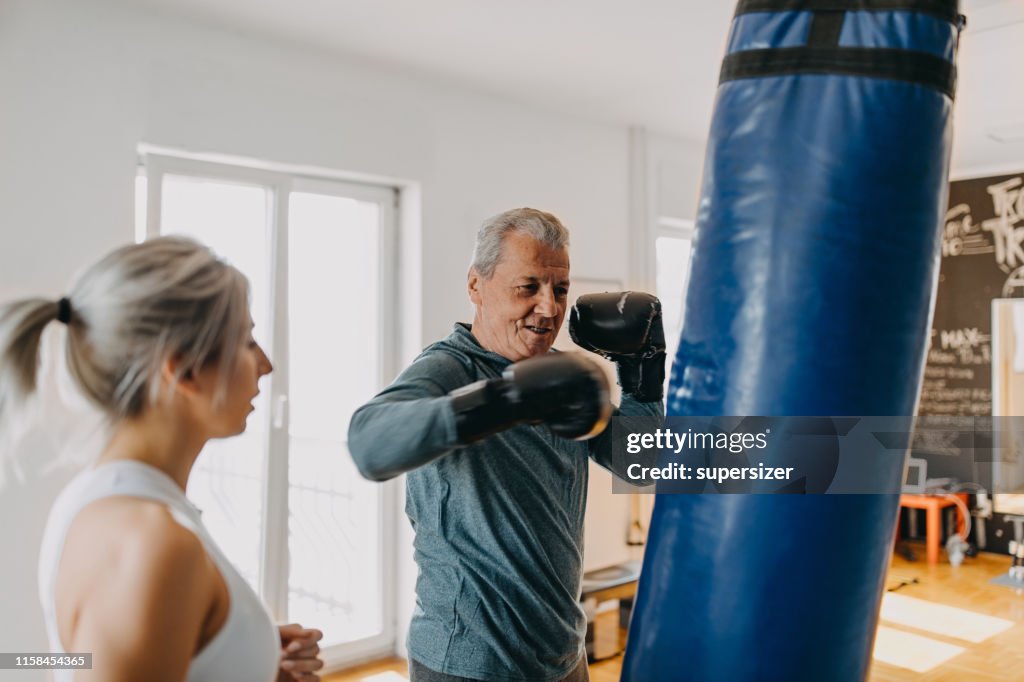Senior man exercising with his personal trainer
