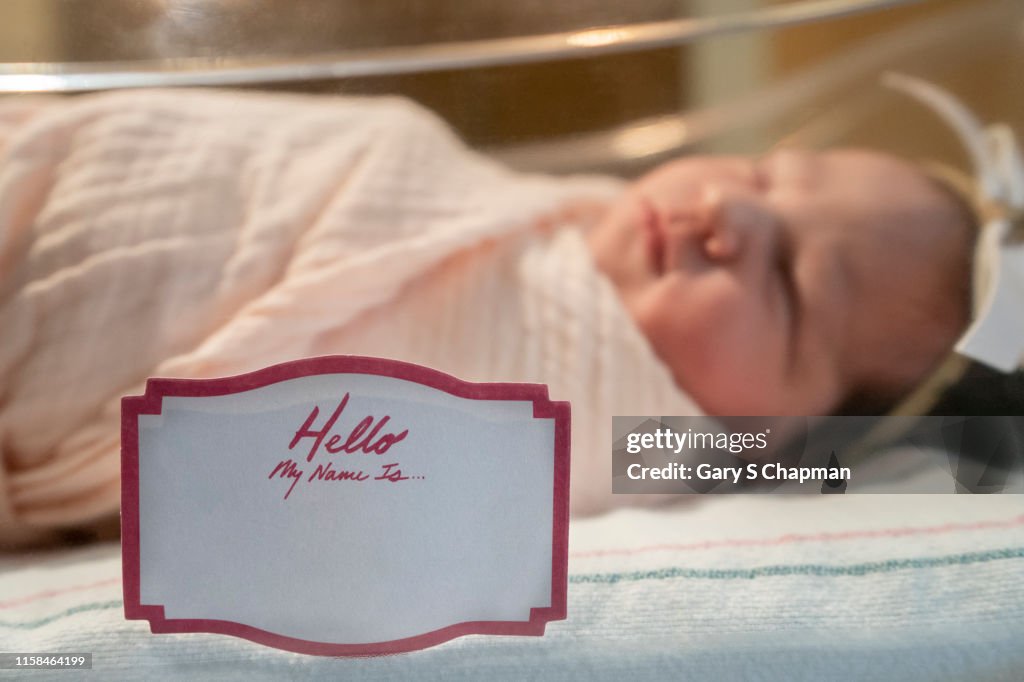 Newborn baby girl with tag my name is