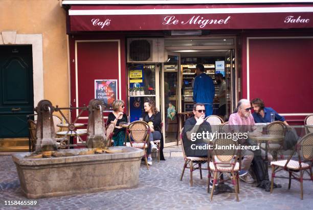 aix-en-provence, france: people relaxing at sidewalk cafe at dusk - french language stock pictures, royalty-free photos & images