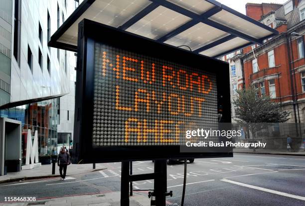 "new road layout ahead" sign in london, uk - traffic light city stockfoto's en -beelden