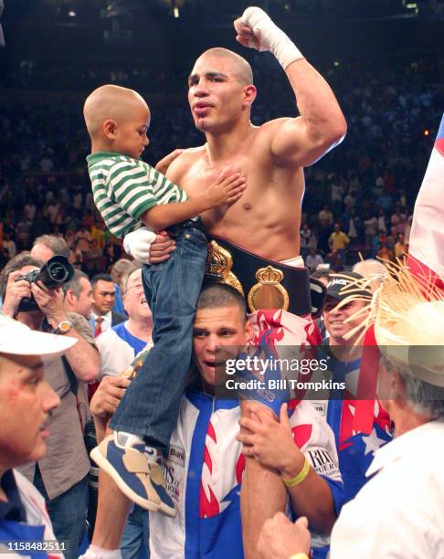 June 9: MANDATORY CREDIT Bill Tompkins/Getty Images Miguel Cotto raises his fist into the air while sitting onthe shoulders of his cornerman and...