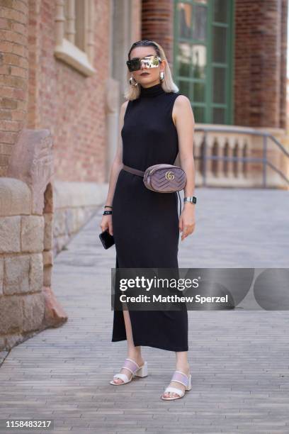 Guest is seen on the street attending 080 Barcelona Fashion Week wearing black sleeveless dress, hip belt bag, white heels on June 26, 2019 in...