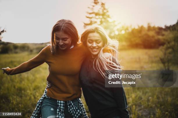 teen mädchen mit spaß bei sonnenuntergang - beste freundinnen stock-fotos und bilder