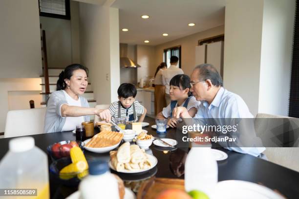 happy taiwanese family having breakfast together - sandwich generation stock pictures, royalty-free photos & images