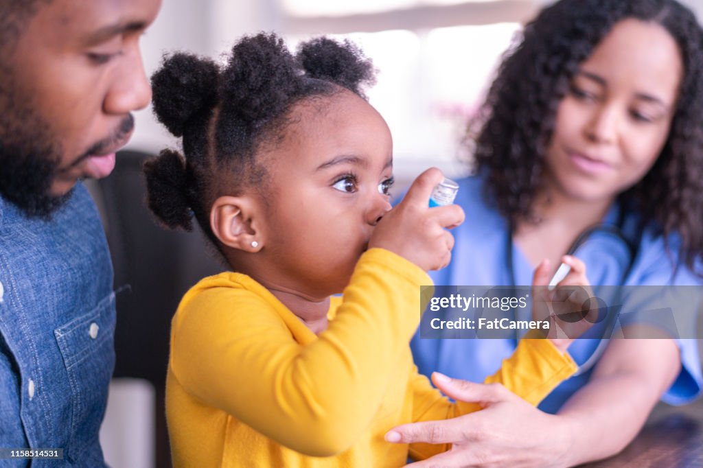 Girl at doctor's appointment using an asthma inhaler