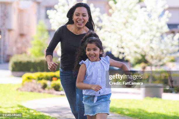 mother and daughter playing tag - family garden play area stock pictures, royalty-free photos & images