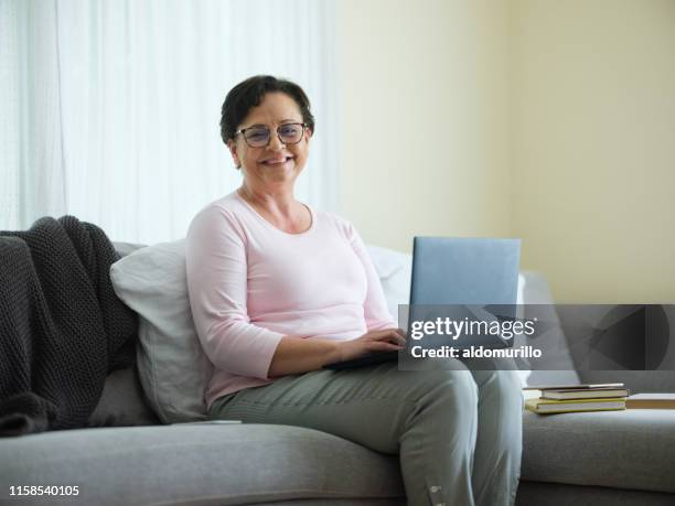 smiling older woman with a laptop - mexican mature women stock pictures, royalty-free photos & images