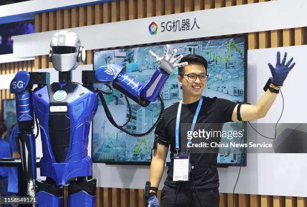 Worker interacts with a robot of robotics startup Roborn Dynamics Ltd on day one of the Mobile World Congress Shanghai 2019 at the Shanghai New...