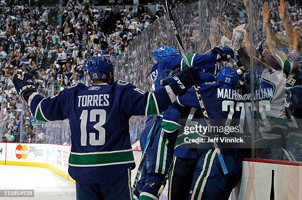 Raffi Torres, Manny Malhotra, Alexander Edler, Kevin Bieksa celebrate Maxim Lapierre of the Vancouver Canucks third period goal during Game Five of...