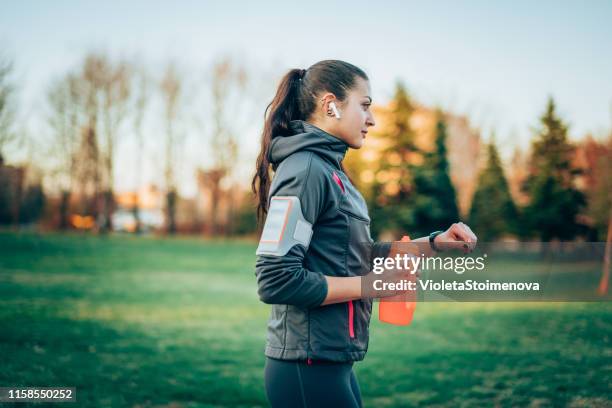 sportswoman using a smart watch - bluetooth headphones stock pictures, royalty-free photos & images