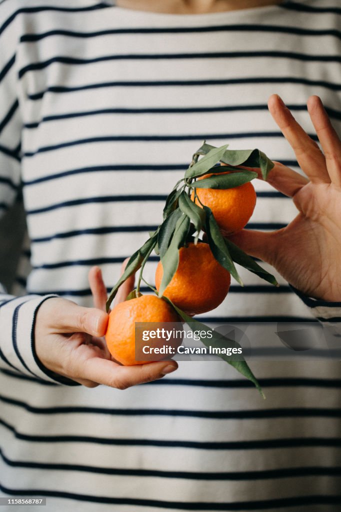 Woman Holding fresh mandarins