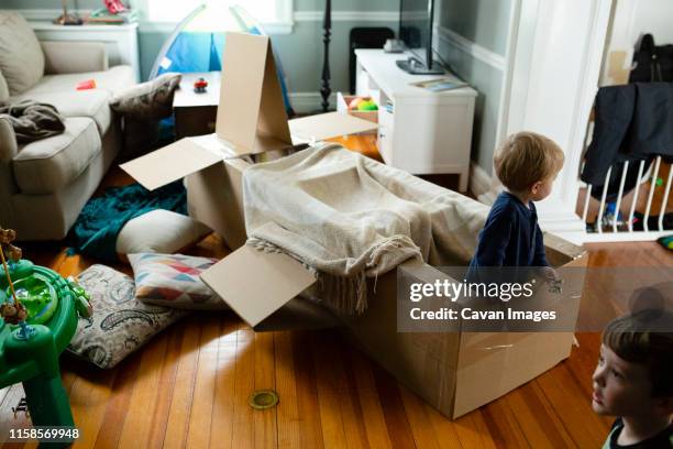 kids engage in pretend play indoors with spacecraft made of cardboard - kids fort stock pictures, royalty-free photos & images