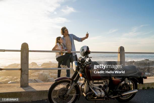 father taking selfie with daughter close to vintage motorcycle - old motorcycles imagens e fotografias de stock