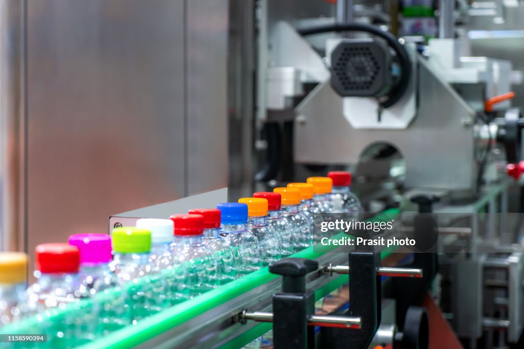 Moving Bottles on Labelling machine for Industry, Clear bottles transfer on Conveyor Belt System.