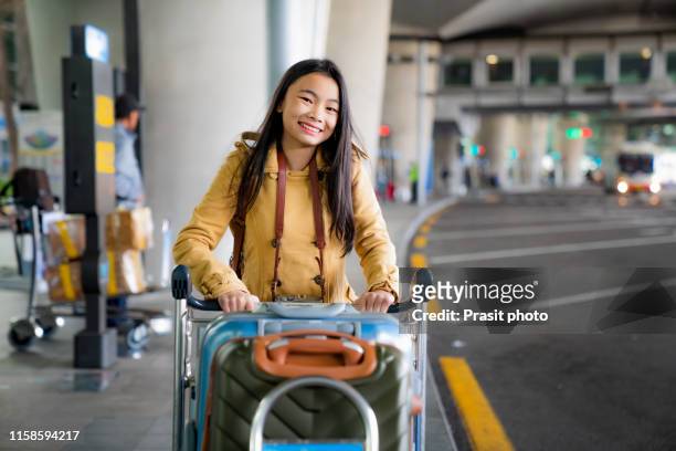 asian woman are carrying baggage trolleys within the airport. - korean teen - fotografias e filmes do acervo