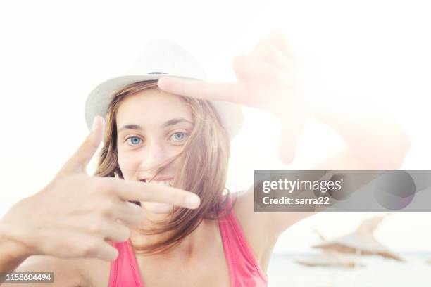 mulher alegre na praia. - dedos fazendo moldura - fotografias e filmes do acervo