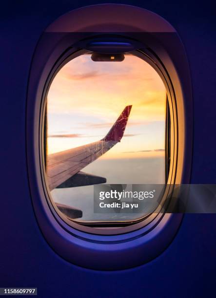view through a airplane window - business class flight stockfoto's en -beelden