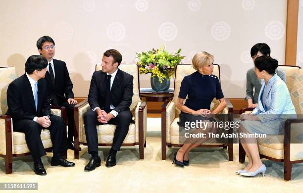 French President Emmanuel Macron talks with Emperor Naruhito while his wife Brigitte talks with Empress Masako during their meeting at the Imperial...