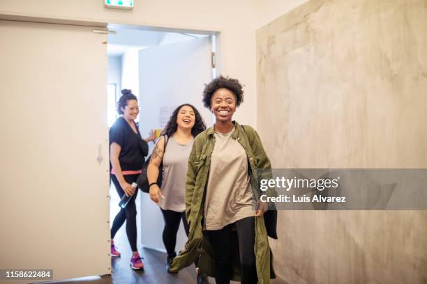 multiracial females entering fitness studio - studio workplace stock-fotos und bilder