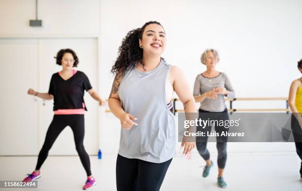 woman learning dance moves in a class - zware lichaamsbouw stockfoto's en -beelden