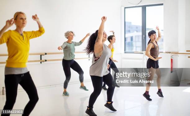 group of women learning fitness dance in class - aerobics stock pictures, royalty-free photos & images