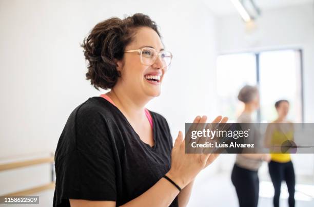 cheerful woman clapping hands at fitness studio - dicke menschen stock-fotos und bilder