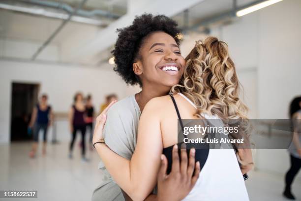 dance instructor greeting students at fitness studio - gym friends stock-fotos und bilder