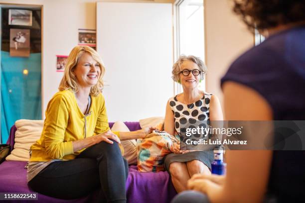 mid adult women talking in a dance class dressing room - dressing room stock-fotos und bilder