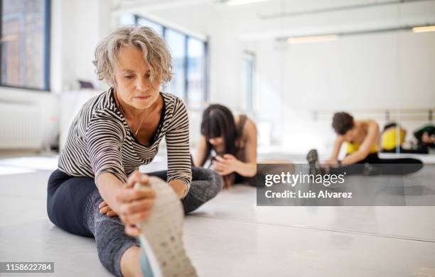 women stretching in dance class - frau zwischen 50 und 60 stock-fotos und bilder