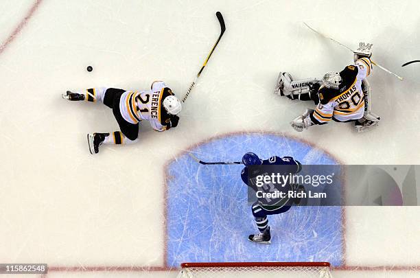 Tim Thomas of the Boston Bruins makes a save against Raffi Torres of the Vancouver Canucks as Andrew Ference falls to the ice during Game Five of the...