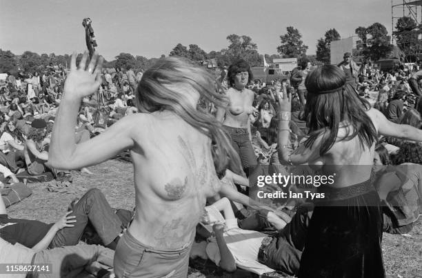 Topless women fans wearing body paint, dancing in the audience at the Glastonbury Fair music festival, 22nd - 26th June 1971. Later renamed the...