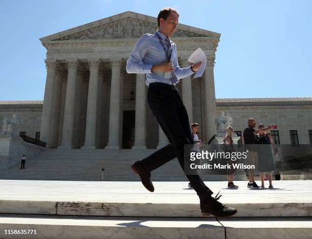 News intern Dillion Farneti runs with a decision released by the U.S. Supreme Court, on June 27, 2019 in Washington, DC. The high court blocked a...