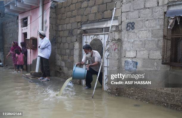 Resident removes rains water from his house during heavy monsoon rains in Karachi on July 30, 2019.