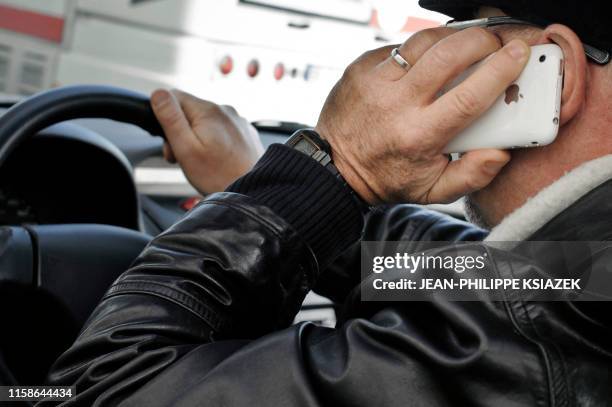 Une personne téléphone au volant de sa voiture, le 4 janvier 2012 à Lyon, alors que téléphoner avec son appareil en main en conduisant devient une...