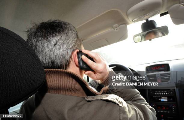 Un automobiliste utilise son téléphone portable alors qu'il conduit sur la RN 137 entre Rennes et Nantes, le 04 janvier 2012. Téléphoner avec son...