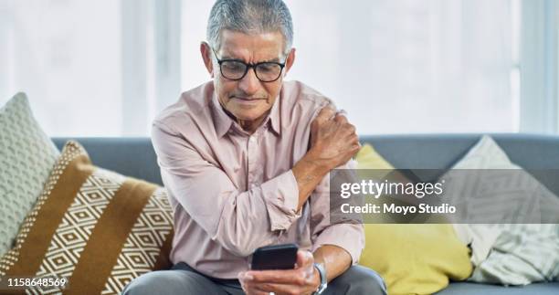 wat zegt het internet over pijn in de schouder? - looking over his shoulder stockfoto's en -beelden