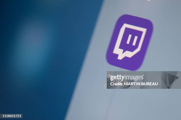 This illustration picture taken on July 24, 2019 in Paris shows the US live streaming video platform Twitch logo application on the screen of a...