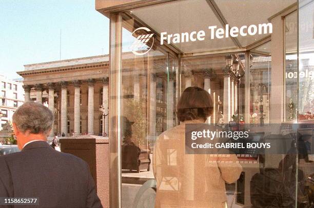 Une personne téléphone, le 22 septembre, dans une cabine de France-Télécom installée devant le palais de la Bourse à Paris. Le ministère des Finances...