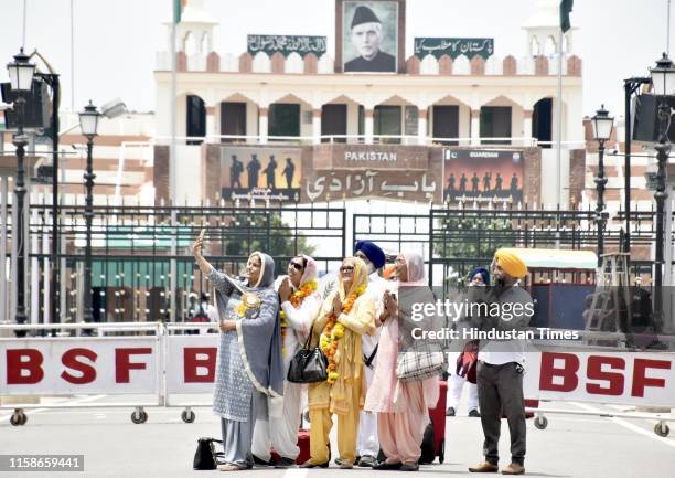 Sikh devotees wave before crossing the Attari - Wagah international border, at Attari border on July 30, 2019 near Amritsar, India. They will be...