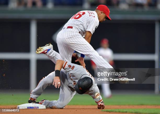 Cesar Hernandez of the Philadelphia Phillies jumps over Mike Yastrzemski of the San Francisco Giants after putting him out at second base after in...