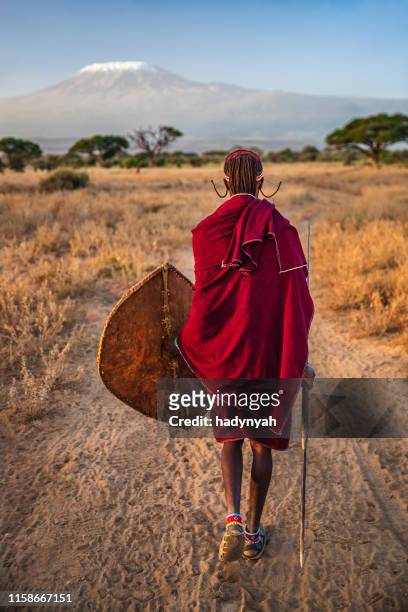 warrior from maasai tribe, mount kilimanjaro on background, kenya, africa - mt kilimanjaro stock pictures, royalty-free photos & images