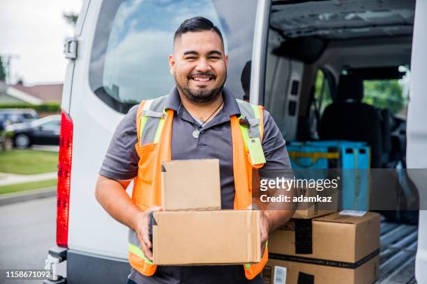 delivery man with packages - carteiro imagens e fotografias de stock
