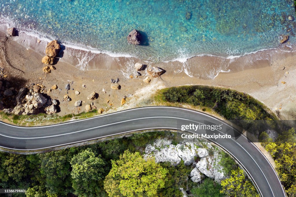 Strada sul mare che si avvicina a una spiaggia, vista dall'alto