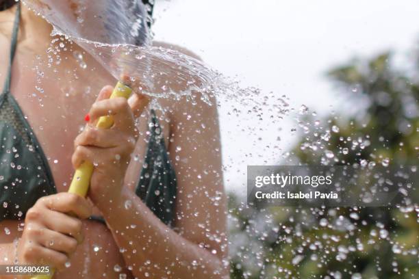 woman splashing outdoors - hose stock pictures, royalty-free photos & images