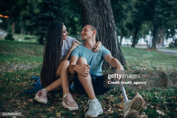 young couple in park - amputee woman imagens e fotografias de stock